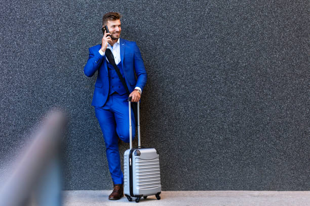 istock Handsome young man on business trip walking with his luggage. 996238376