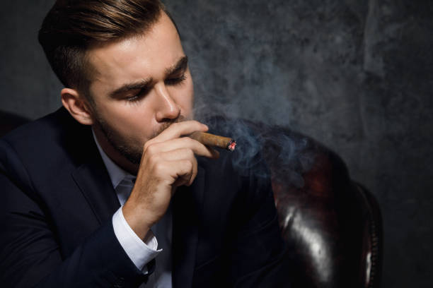 istock Handsome rich man is smoking cigar 996240306
