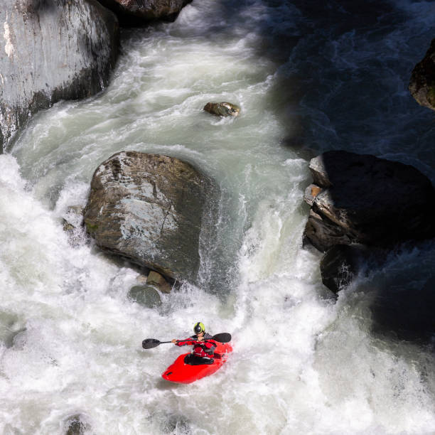 istock Man kayaking against rough white water in red kayak 996245162