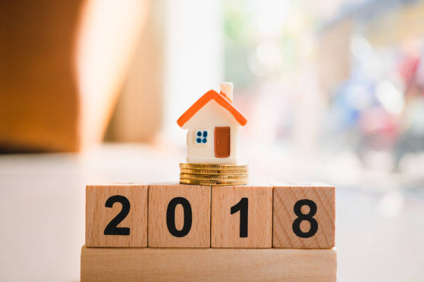 istock Miniature house on wooden block year 2018 996246232