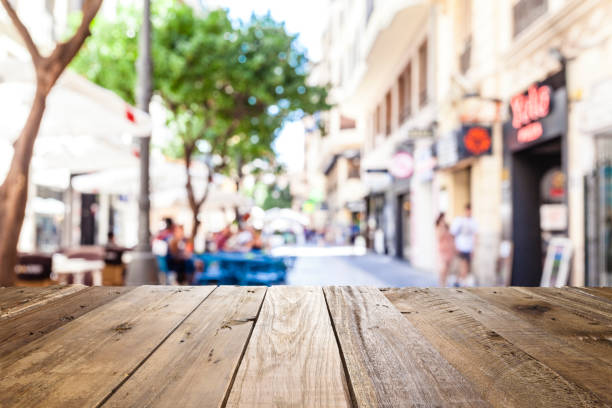 Empty wooden table with defocused sidewalk cafe at background