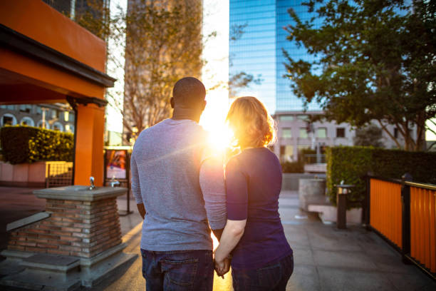 Two businesspeople looking at each other and smiling, enjoying a moment together in a modern urban setting