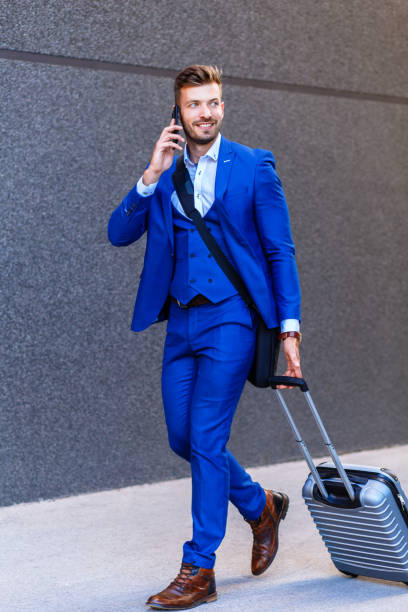 istock Handsome young man on business trip walking with his luggage. 996262636