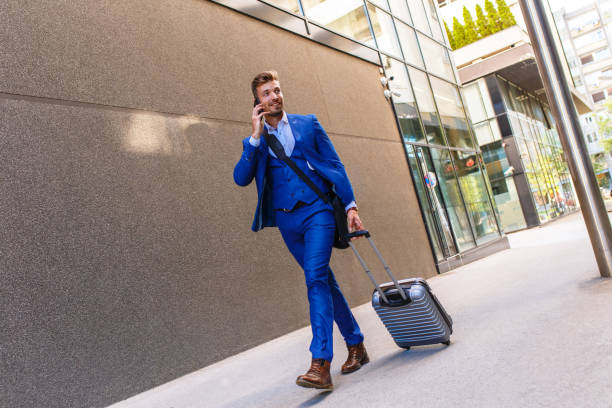 istock Handsome young man on business trip walking with his luggage. 996263098