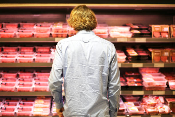 adolescente compra um pacote de carne no supermercado - carne vermelha - fotografias e filmes do acervo