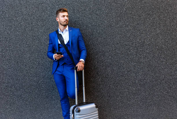 istock Handsome young man on business trip walking with his luggage. 996266344