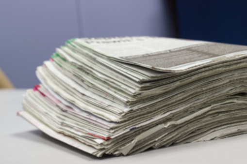 Blurred - Newspaper Stack on white table in work office