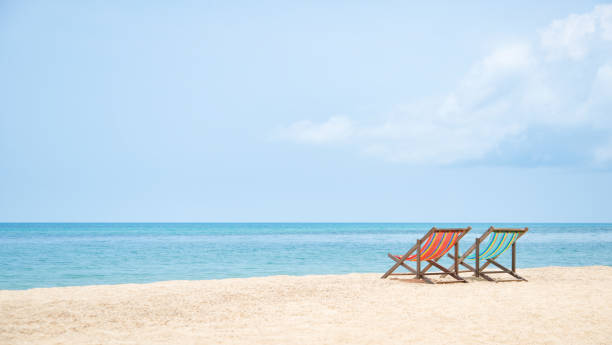 istock Two deckchairs facing out to sea on an idyllic deserted beach. 996267908