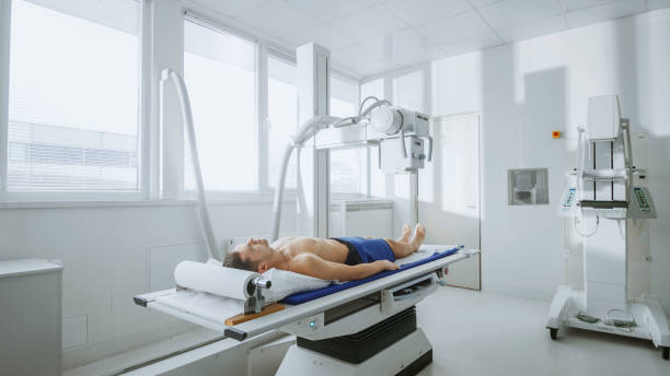 In the Hospital, Man Lying in Bed during X-Ray Machine Scanning Procedure. Scanning for Fractures, Broken Limbs, Injuries, Cancer or Tumor. Modern Hospital with Technologically Advanced Medical Equipment. en el hospital, el hombre acostado en la cama durante el procedimiento de análisis de la máquina de rayos x. análisis de las fracturas, roto de la extremidades, lesiones, cáncer o tumor. moderno hospital con equipos médicos de tecnología avanzada.