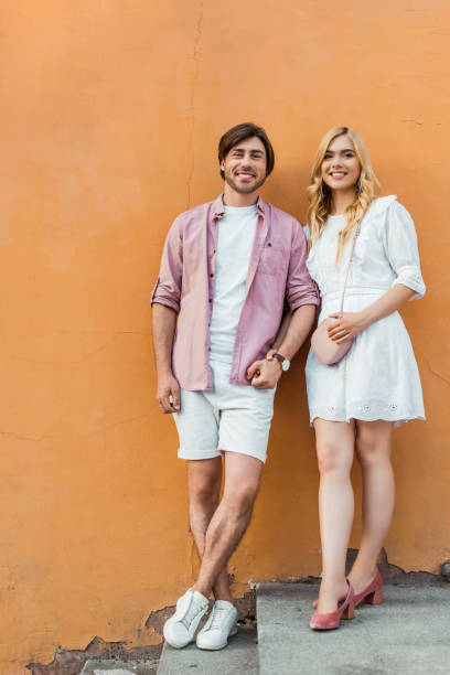 istock young stylish couple holding hands while standing against city building wall 996271506