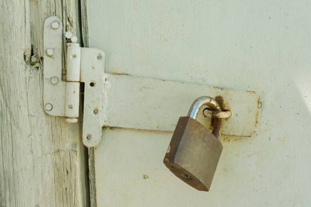 istock Rusty closed lock on old wooden white cracked painted door 996284560