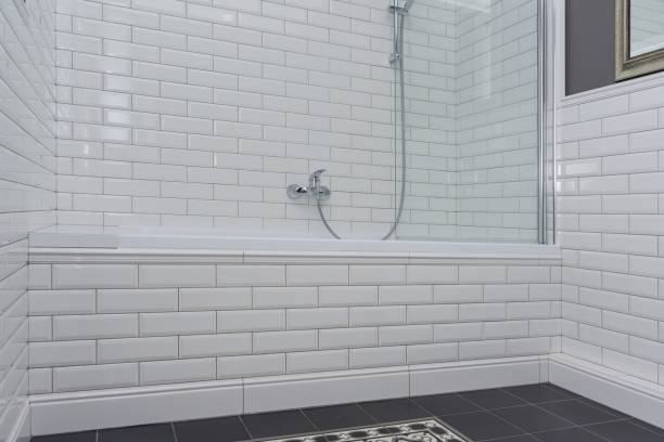 istock Bathroom interior close-up. The walls are painted gray, covered with decorative ceramic tiles with white glossy bricks. 996284632