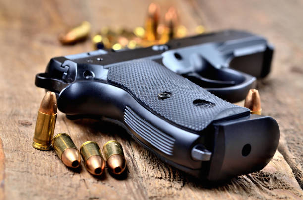 istock 9mm pistol and bullets on old wooden table 996285152