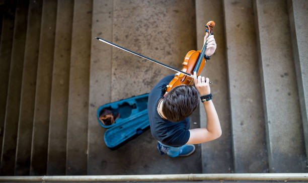straßenmusiker spielt violine - street musician stock-fotos und bilder