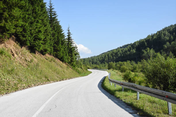 istock Mountain road. Old road through the forest 996285872