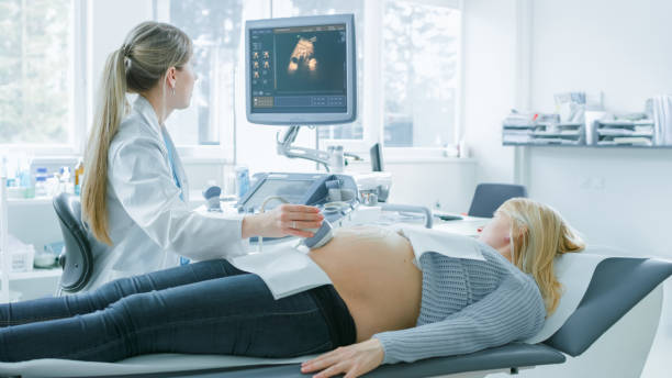 在醫院裡, 孕婦得到超聲波檢查, 產科醫生在電腦螢幕上檢查健康嬰兒的照片。幸福未來的母親等著她的孩子出生。 - future 個照片及圖片檔