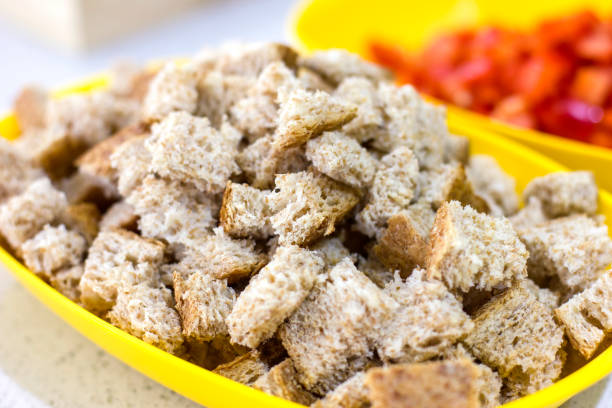 Crackers for Caesar salad. Pieces of bread in yellow bowl