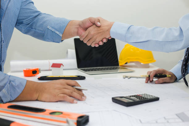 istock Architect and businessman shaking hands meeting discuss a plan about the construction project of real estate. Agreement and are willing to work together. 996341940