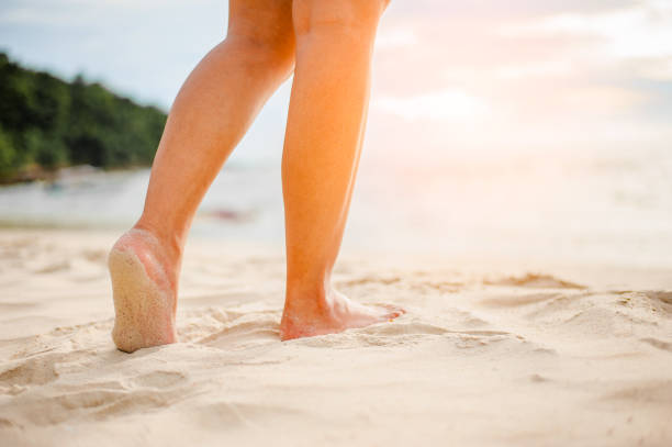 istock Woman walking on the beach at sunset. 996344754