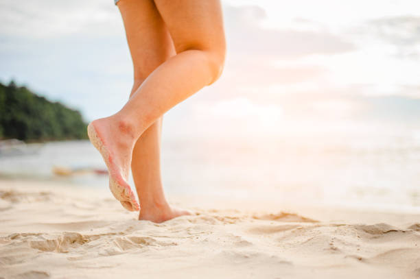istock Woman walking on the beach at sunset. 996344766
