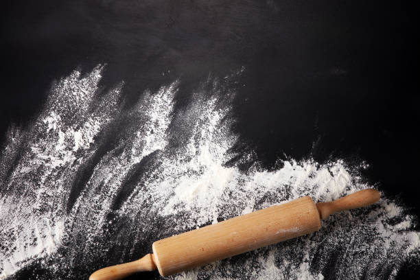 istock Baking background with the rolling pin with flour. On the dark table. Free space for text 996368924