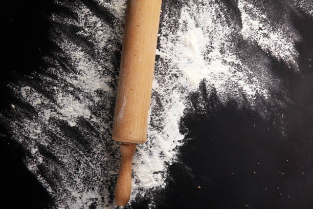 istock Baking background with the rolling pin with flour. On the dark table. Free space for text 996371710