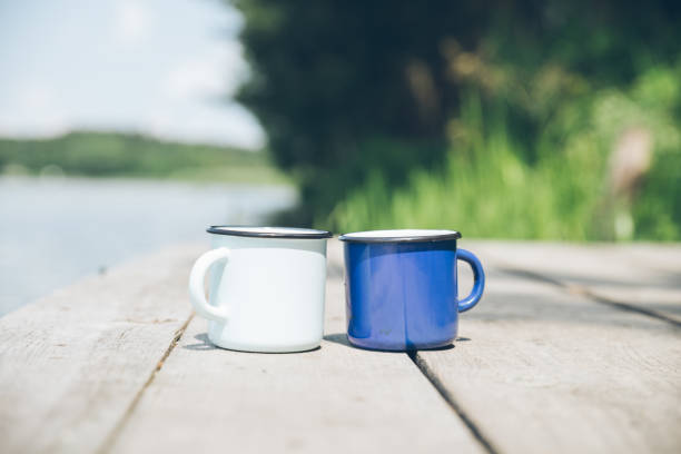 istock two metal cups with tea. river on background. summer time concept 996372624