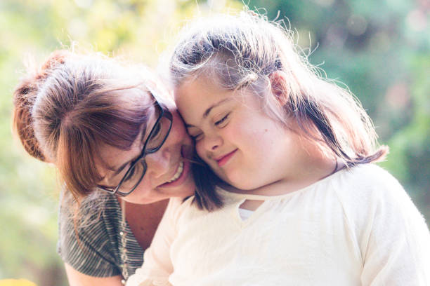 portrait of a mother with her daughter of 12 years old with autism and down syndrome in daily lives - women common 40s candid imagens e fotografias de stock