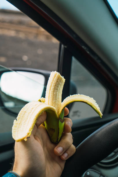 istock Person eating banana in car 996395974