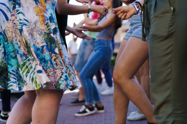 Faceless shot of various people enjoying dancing at street having fun all together.