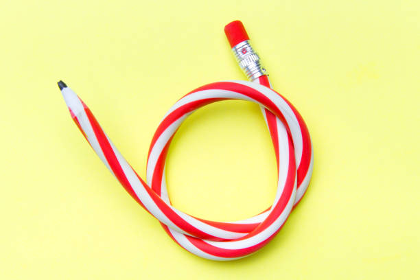 istock Flexible pencil on a yellow background. Bent pencils two-color 996415934