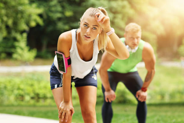 istock Young couple jogging in park 996416282