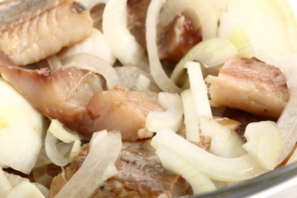 istock Sliced salted herring with fresh onion close-up. Background 996438142