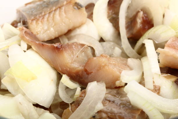 istock Sliced salted herring with fresh onion close-up. Background 996438152