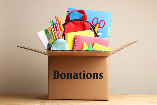 Different school supplies in a cardboard box