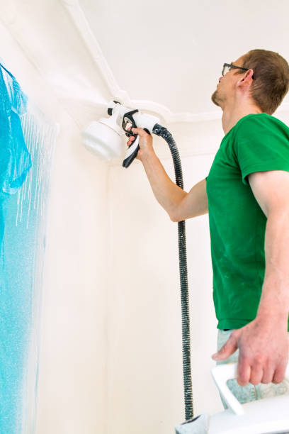 istock Man painting walls using spray gun. 996442838