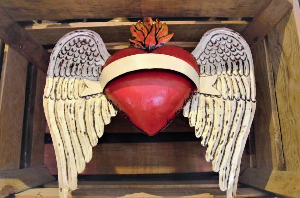 Mexican art is fun, creative, and colorful. This heart with wings is being displayed inside of a wooden box. It's a popular kind of heart in Mexico.