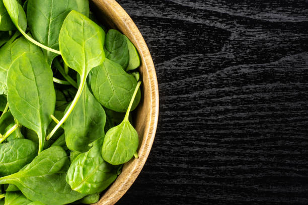 istock Fresh raw green spinach on black wood 996469246