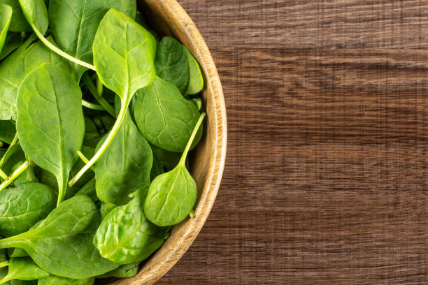 istock Fresh raw green spinach on brown wood 996471312