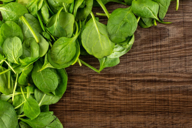 istock Fresh raw green spinach on brown wood 996471448