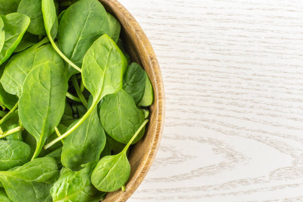 Fresh raw green spinach on grey wood
