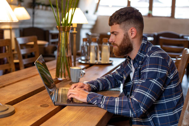 istock Young professional surfing the Internet on his laptop in a cafe 996472626