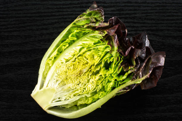 istock Fresh raw lettuce red little gem on black wood 996475744