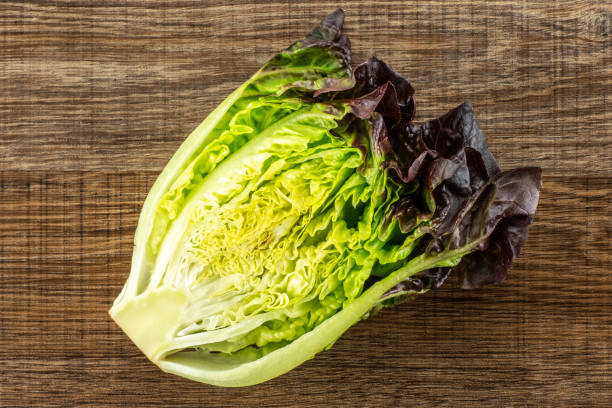 istock Fresh raw lettuce red little gem on brown wood 996475832
