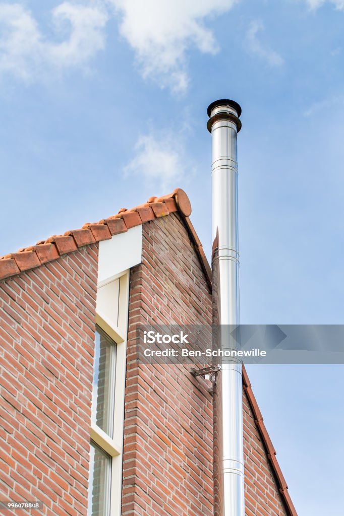 Metal Chimney Pipe On Facade Of House Stock Photo - Download Image Now -  Chimney, Steel, Wood Burning Stove - iStock