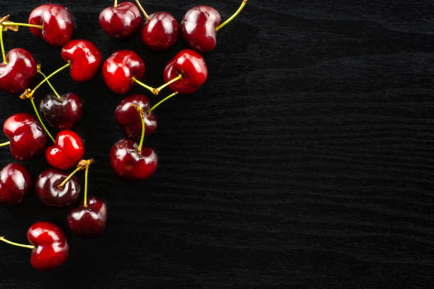 istock Fresh raw sweet red cherry on black wood 996486894
