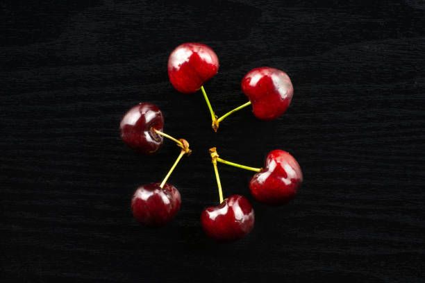 istock Fresh raw sweet red cherry on black wood 996486900