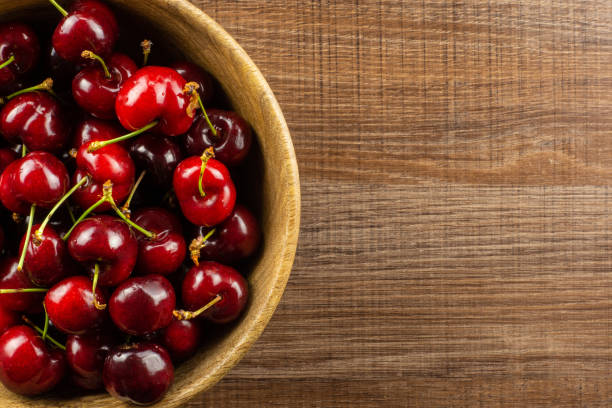 istock Fresh raw sweet red cherry on brown wood 996486926