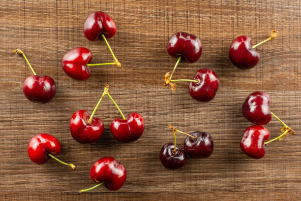 istock Fresh raw sweet red cherry on brown wood 996486986