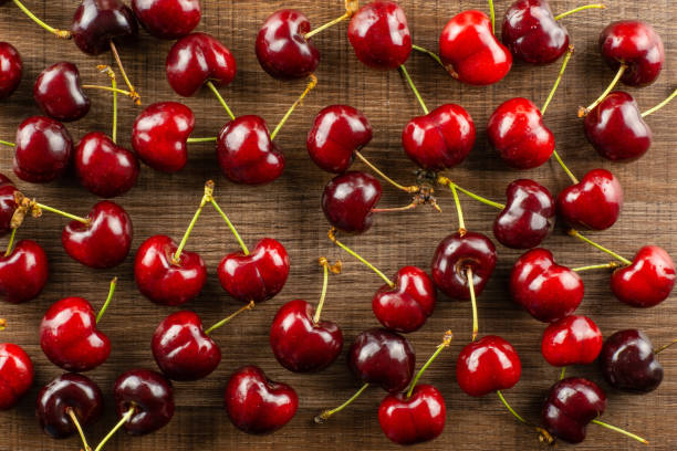 istock Fresh raw sweet red cherry on brown wood 996487008